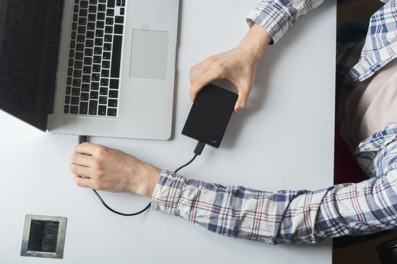 Man at computer doing data backup onto external device