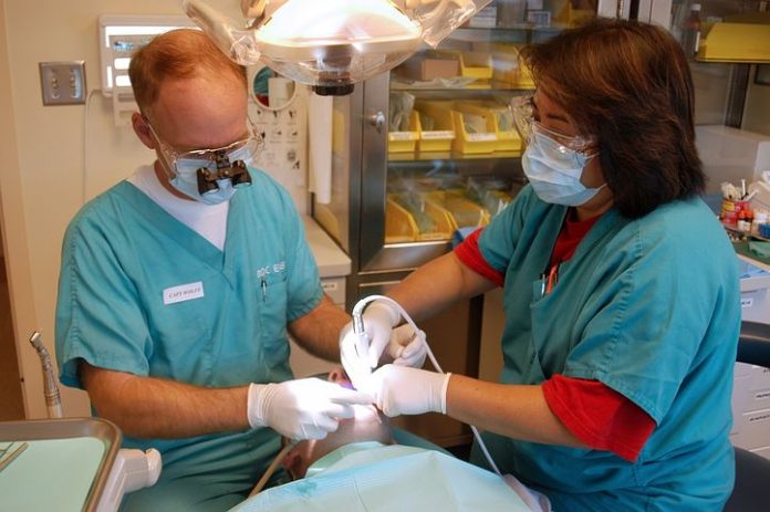 Two dentists performing a wisdom teeth removal procedure in Mulgrave